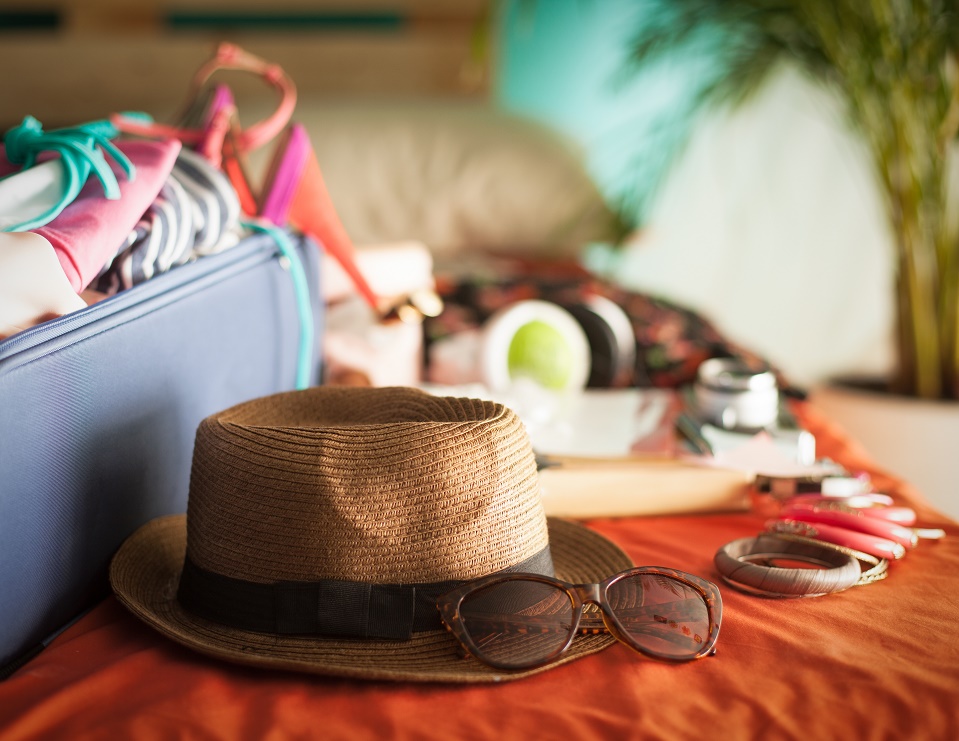 maleta con ropa de verano, sombrero y gafas de sol