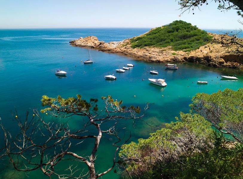 Cala Sa Tuna con barcos atracados y aguas cristalinas