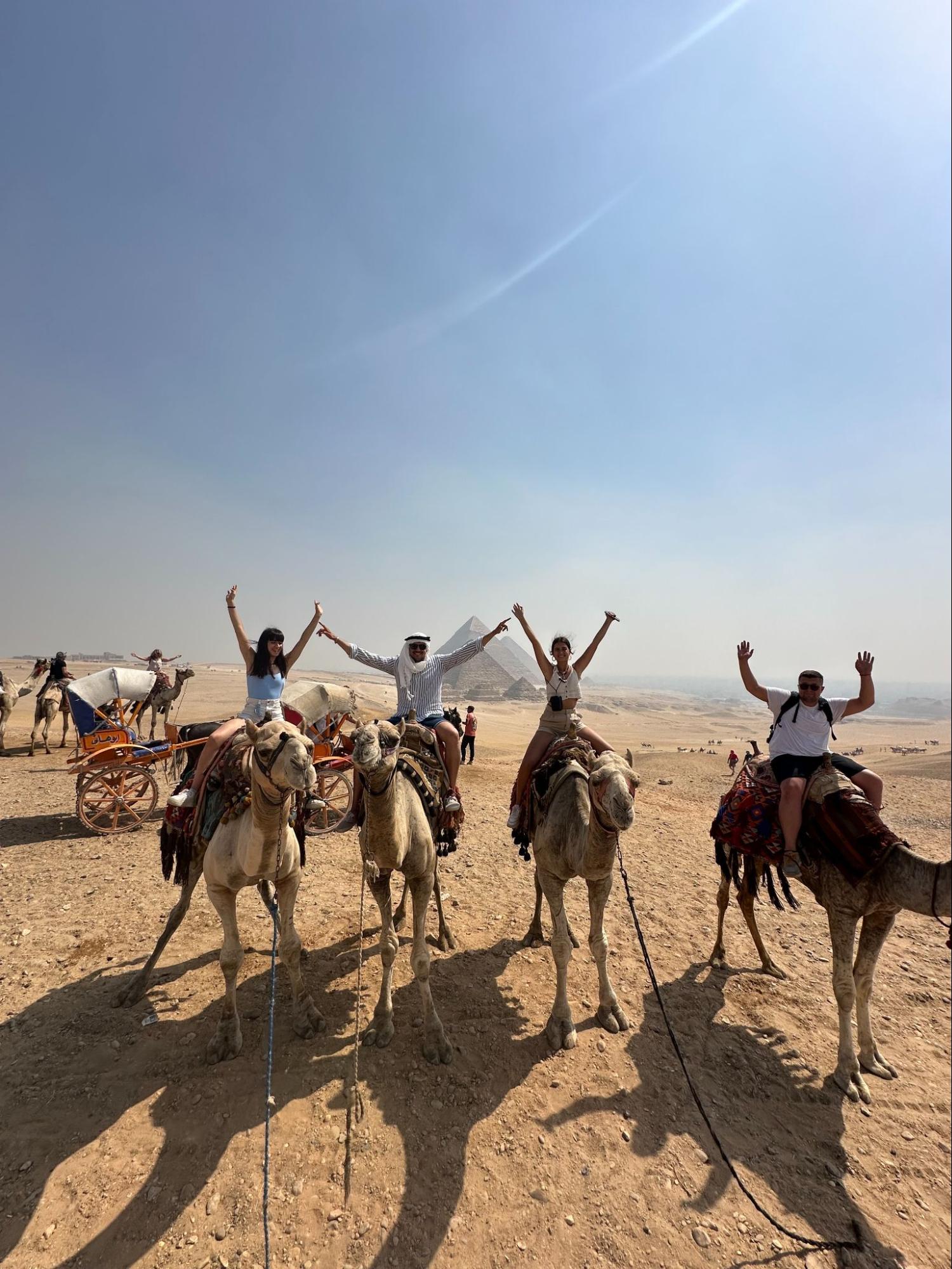 4 Amigos montados en dromedarios por las pirámides de Egipto 