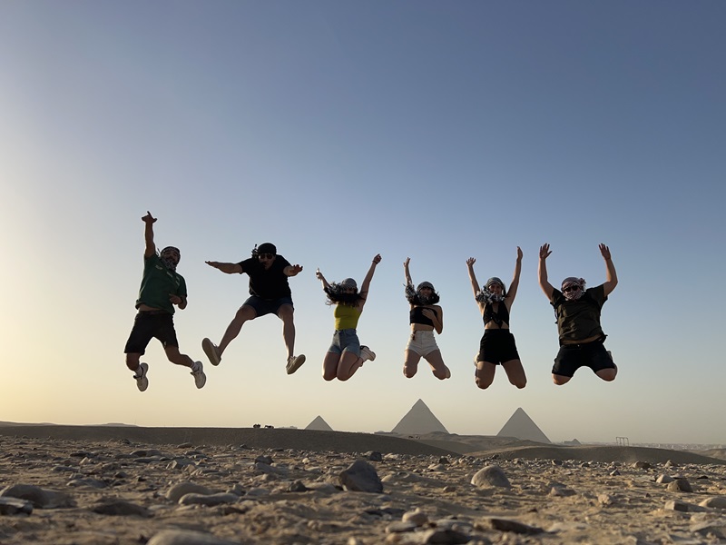 Amigos saltando en un desierto de Egipto 